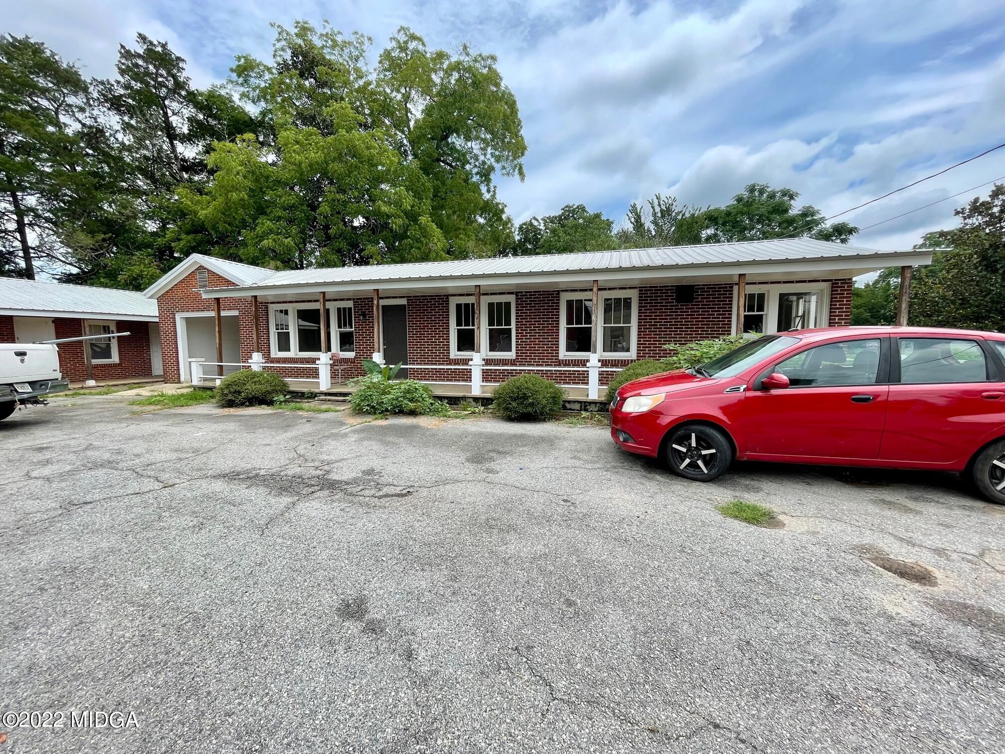 102 Asbell Street Irwinton, GA 31042 - Photo 2 of 8 a view of a house with a garden and parking space
