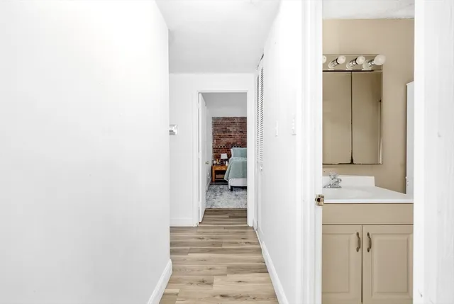 a view of a hallway with wooden floor and staircase