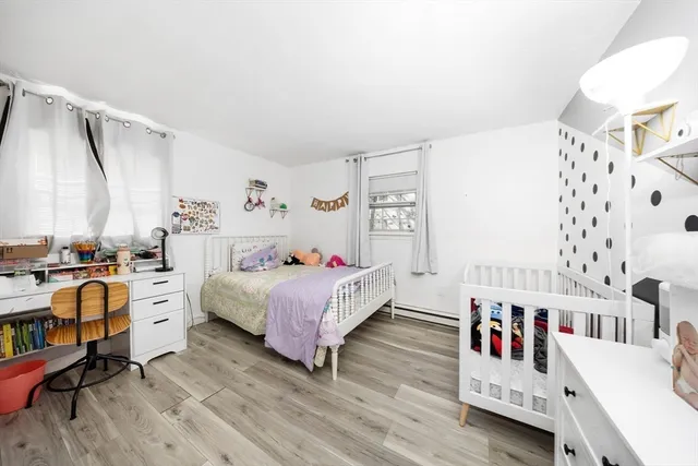 a living room with baby crib furniture and a window