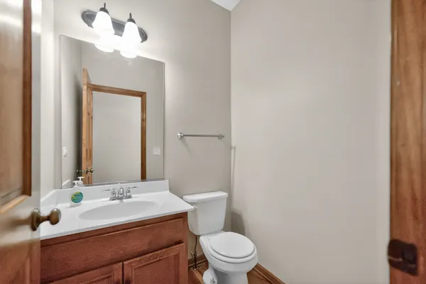 a bathroom with a sink vanity mirror and toilet