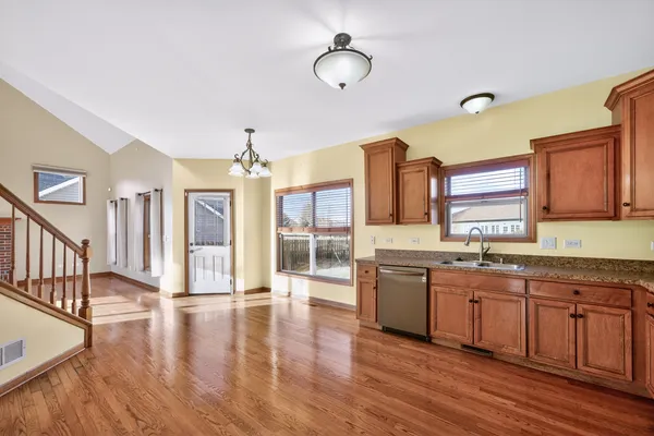 a large kitchen with stainless steel appliances granite countertop a sink and wooden floors
