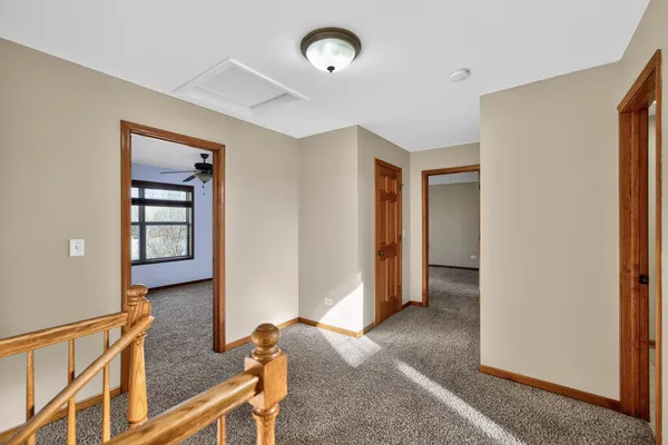 a view of a hallway with wooden floor and a living room