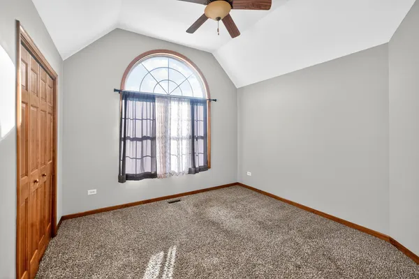 an empty room with windows closet and fireplace