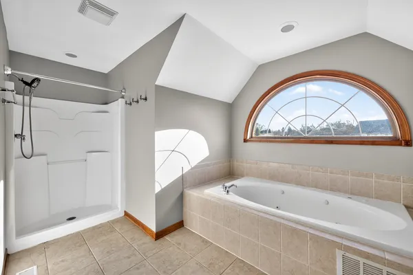 a bathroom with a tub a rug and a window