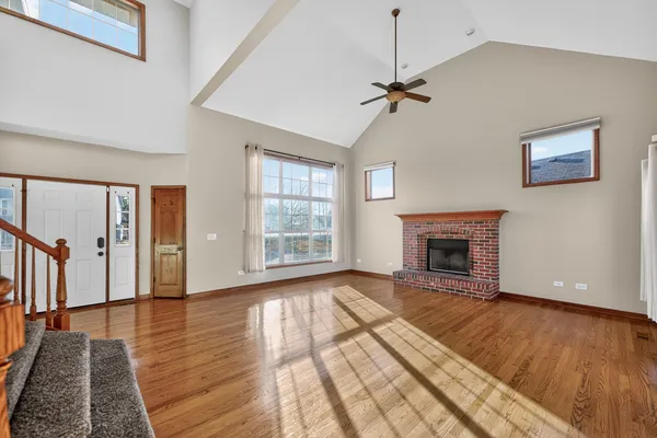 a view of empty room with wooden floor and fireplace