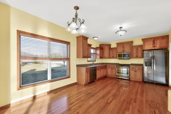 a large kitchen with cabinets wooden floor and stainless steel appliances