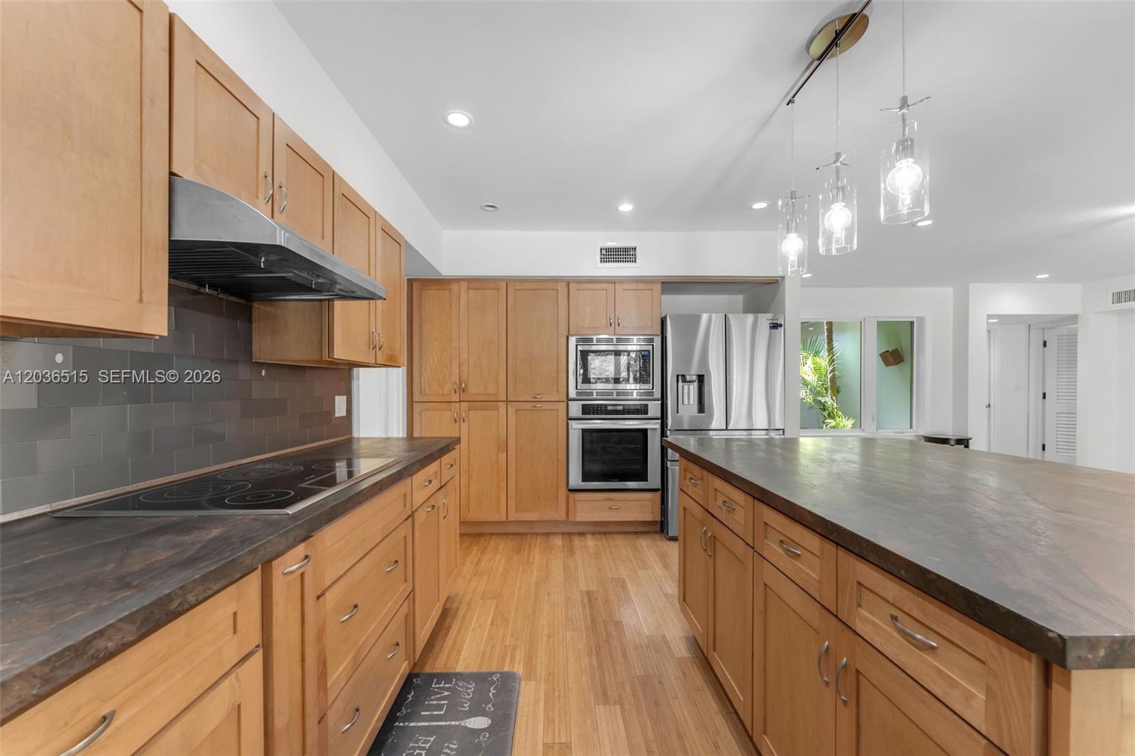 7711 Erwin Road Coral Gables, FL 33143 - Photo 9 of 26 a kitchen with stainless steel appliances granite countertop a sink a stove and a wooden floors