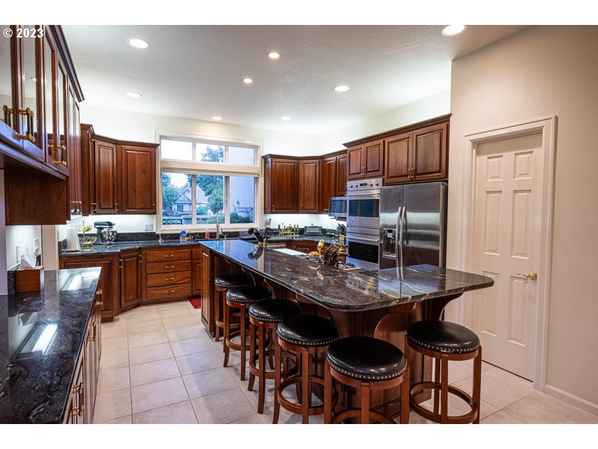 3338 Lakeside Drive Eugene, OR 97401 - Photo 15 of 45 a kitchen with stainless steel appliances kitchen island granite countertop a sink and cabinets