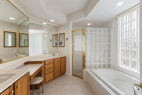 a spacious bedroom with a large bed and a chandelier