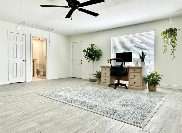 a view of a workspace with furniture and a window