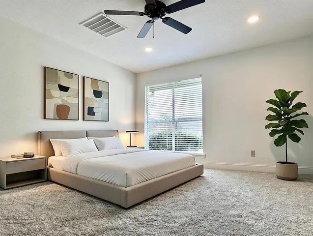 a bedroom with a bed and painting on the wall