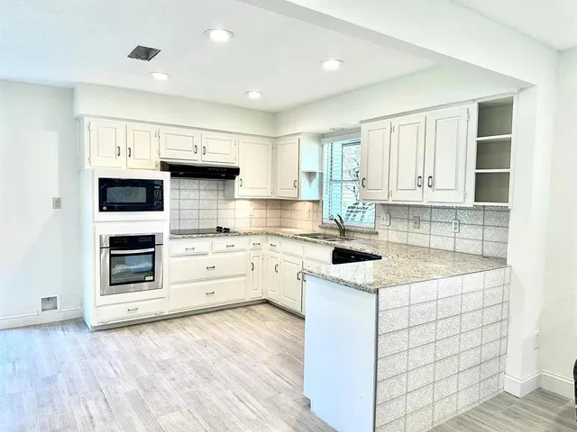 a kitchen with a sink stove and cabinets