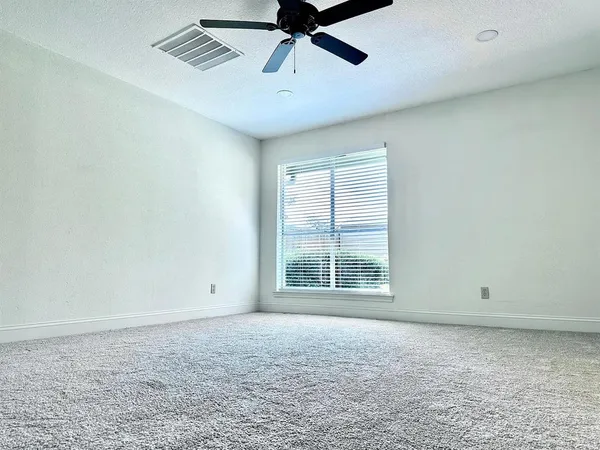 an empty room with chandelier fan
