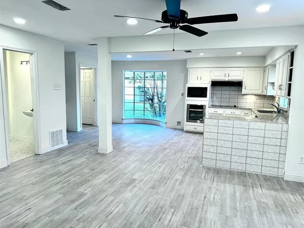a kitchen with stainless steel appliances kitchen island wooden floors and view living room