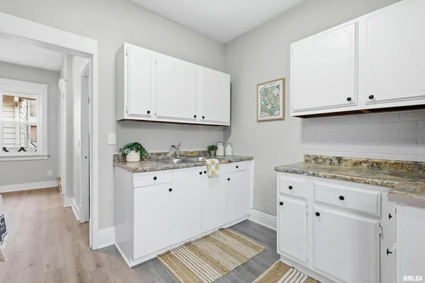 a kitchen with stainless steel appliances granite countertop a stove a sink and white cabinets