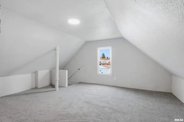 an empty room with a window and stairs