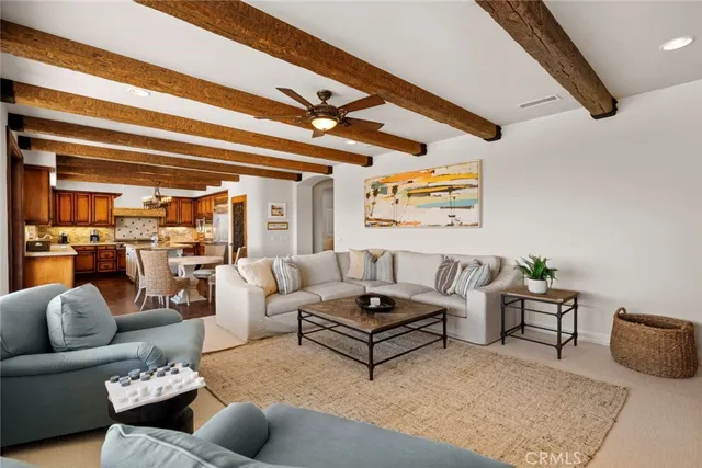 a dining room with wooden floor a fireplace a kitchen and a chandelier