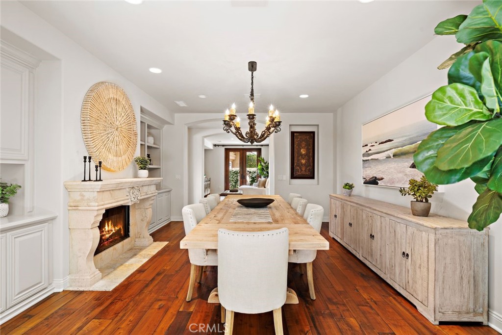 5 Via Monarca Street Dana Point, CA 92629 - Photo 15 of 57 a dining room with wooden floor a fireplace a kitchen and a chandelier
