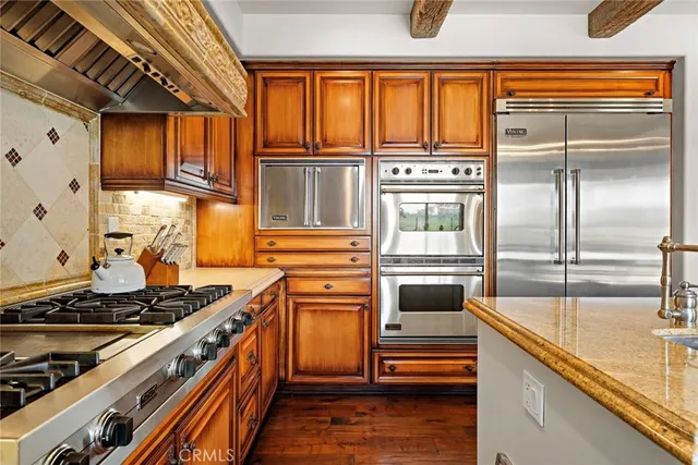 a kitchen with kitchen island granite countertop a stove and a refrigerator