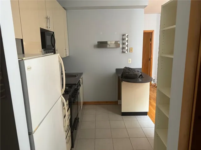 a kitchen with stainless steel appliances a stove a microwave a sink and cabinets