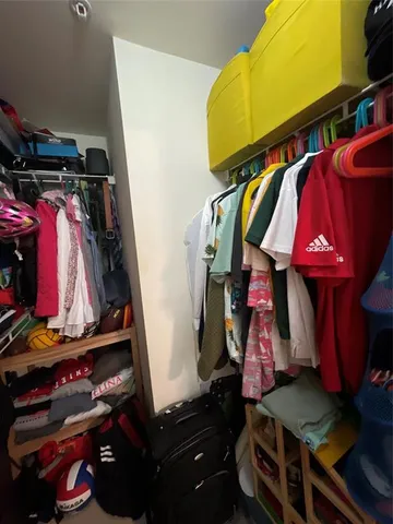 a view of walk in closet with clothes