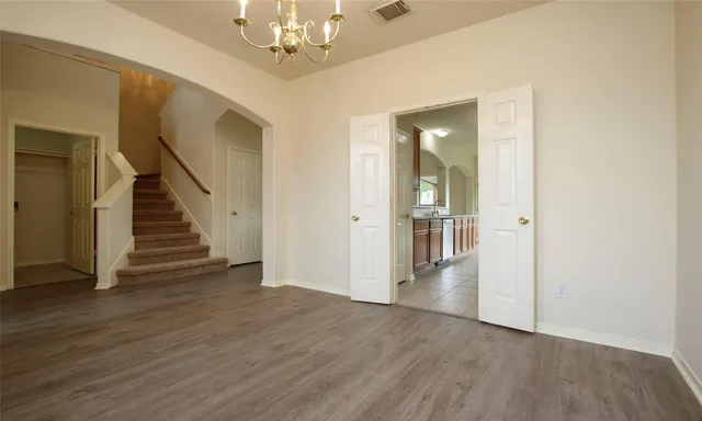 a view of a hallway with wooden floor and staircase