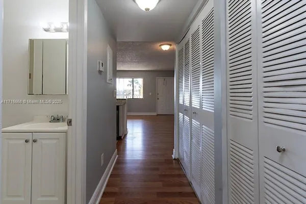 a view of a hallway with wooden floor and staircase