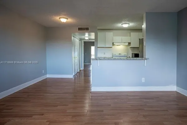 a view of kitchen and empty room