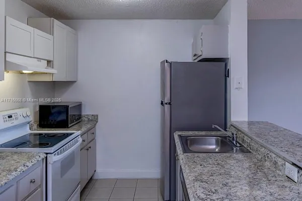a kitchen with stainless steel appliances granite countertop a refrigerator stove and sink