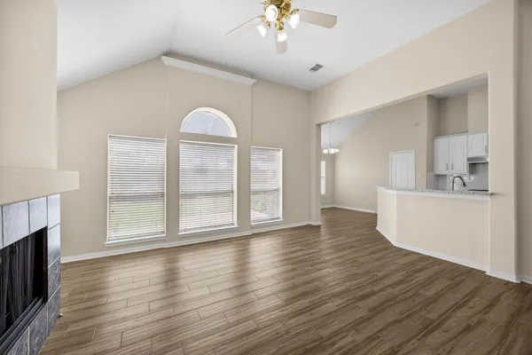 a view of empty room with wooden floor and fireplace