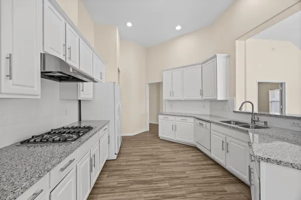 a kitchen with stainless steel appliances granite countertop a sink stove and cabinets