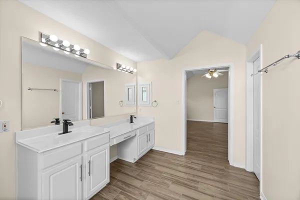 a bathroom with double vanity sinks a vanity lamp and a mirror