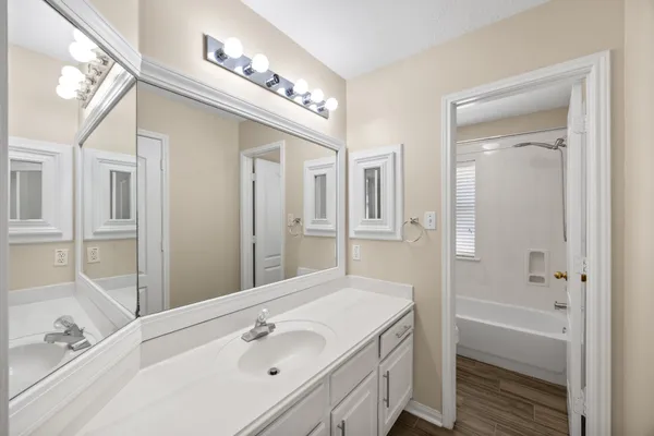a bathroom with a tub a sink and mirrors