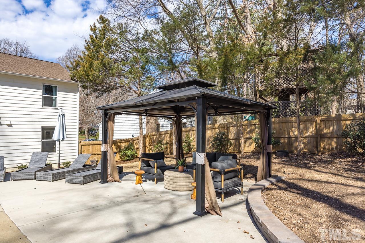 4308 Hickory Ridge Drive Raleigh, NC 27609 - Photo 32 of 46 a view of a patio with table and chairs under an umbrella with large trees