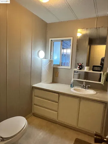 a bathroom with a toilet a sink and mirror