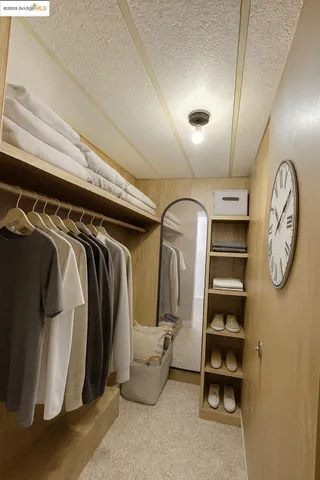 a view of walk in closet with clothes and shoes