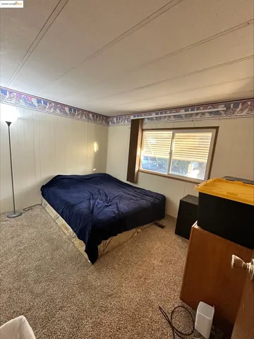 a large bed sitting in a room next to a window