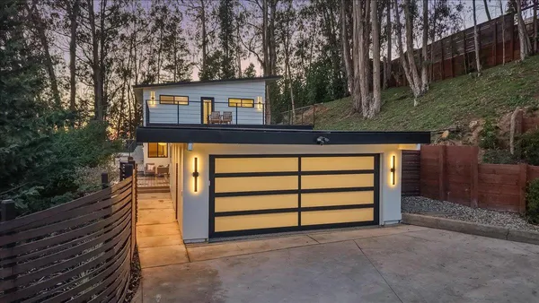 a view of a house with backyard and trees