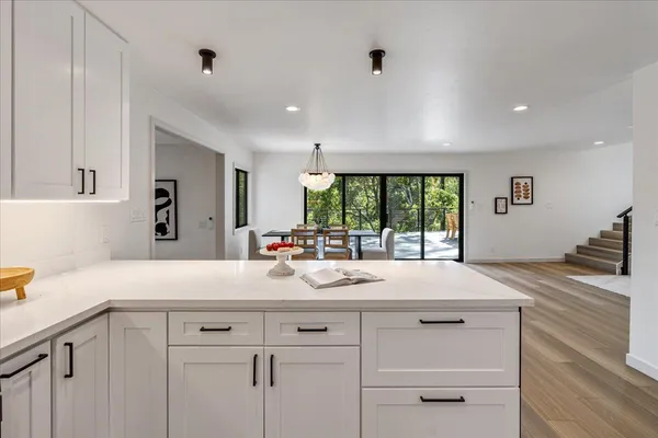 a living room with stainless steel appliances furniture a dining table and chairs