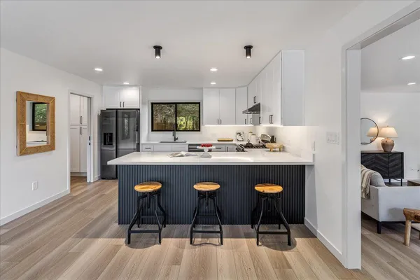 a kitchen with a refrigerator and a stove top oven