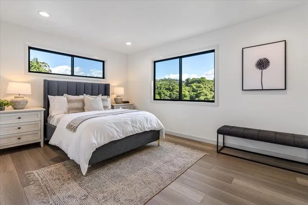 a bedroom with a bed and wooden floor
