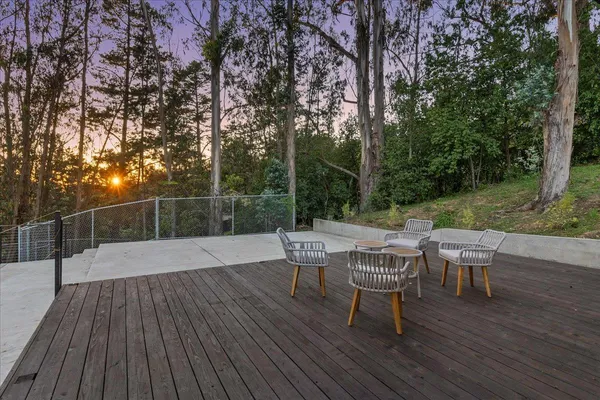 a view of a wooden deck with chairs and a yard