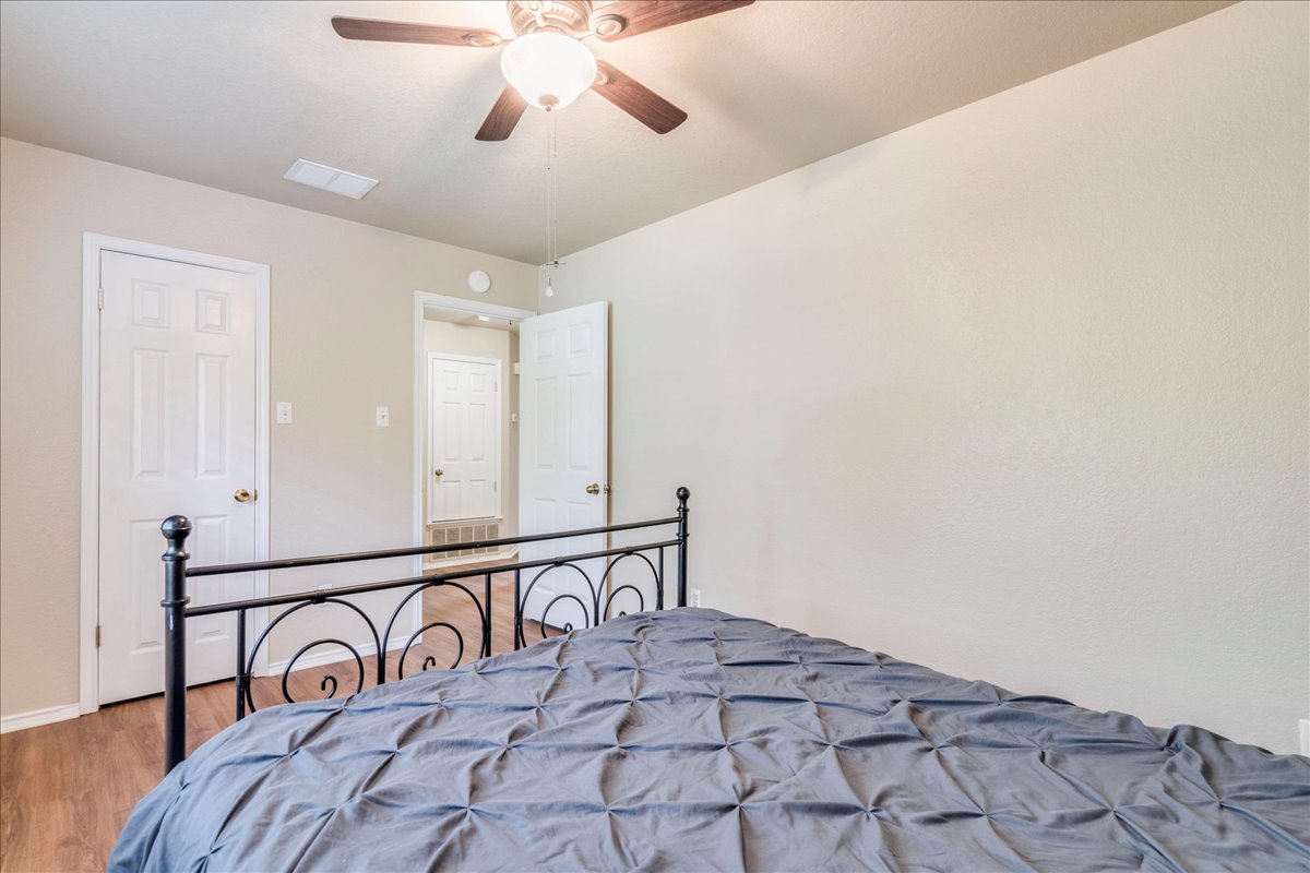 9300 Tea Rose Trail Austin, TX 78748 - Photo 24 of 33 Comfortable bedroom with wood-look flooring and a classic ceiling fan.