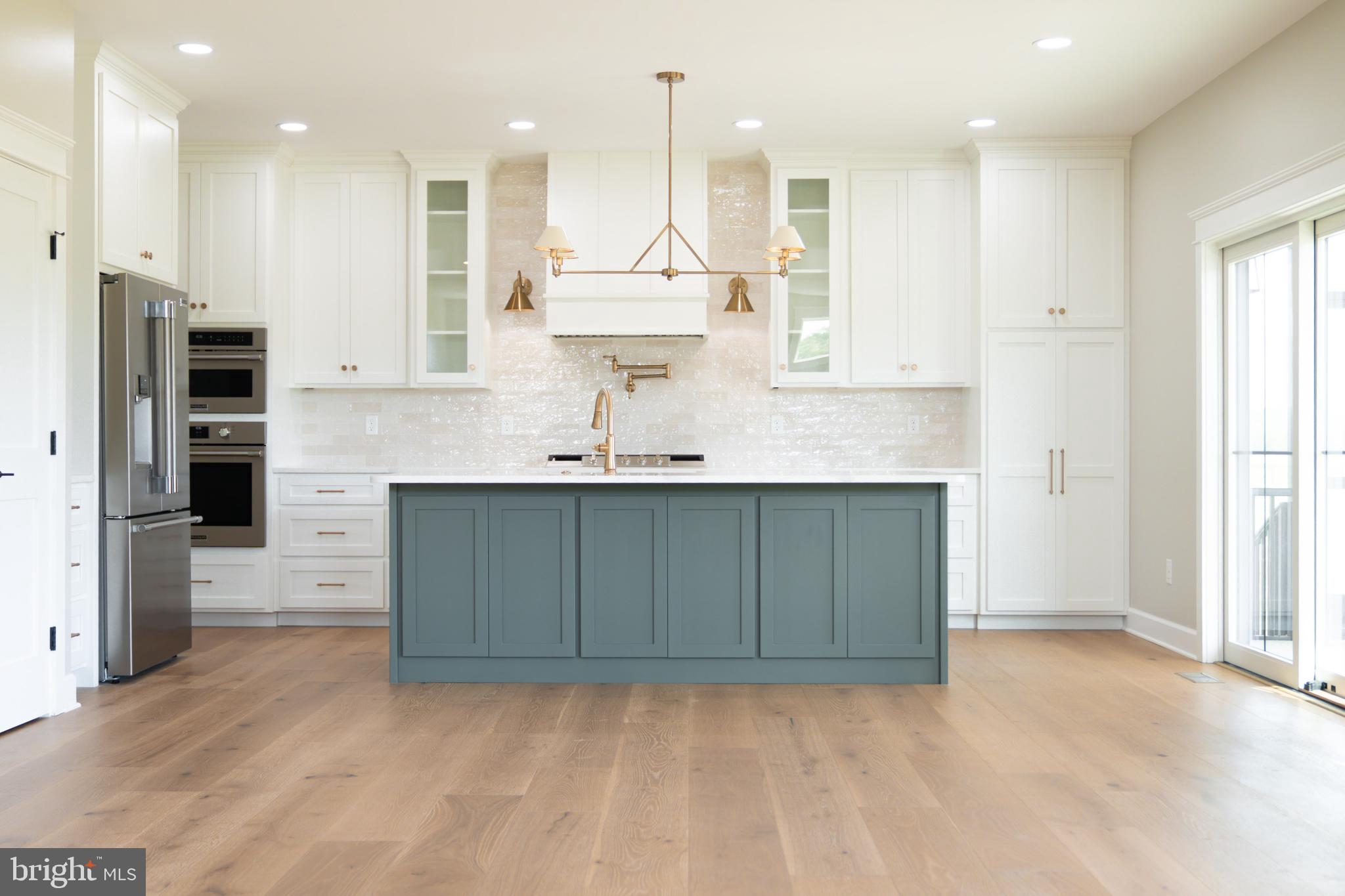 22430 Hummingbird Road Ellendale, DE 19941 - Photo 3 of 39 a kitchen with kitchen island granite countertop a sink refrigerator and cabinets