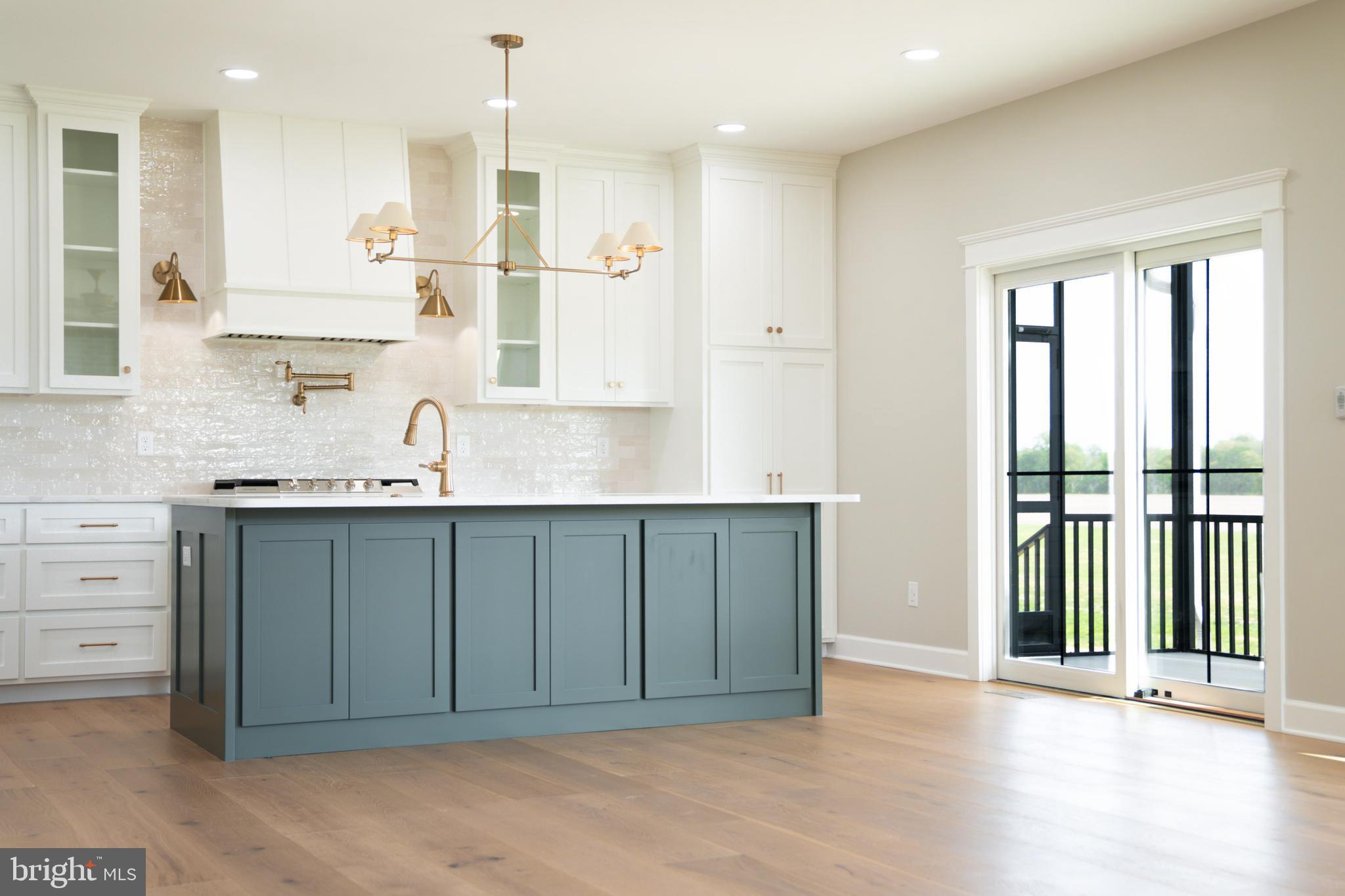 22430 Hummingbird Road Ellendale, DE 19941 - Photo 4 of 39 a kitchen with kitchen island granite countertop a sink cabinets and stainless steel appliances