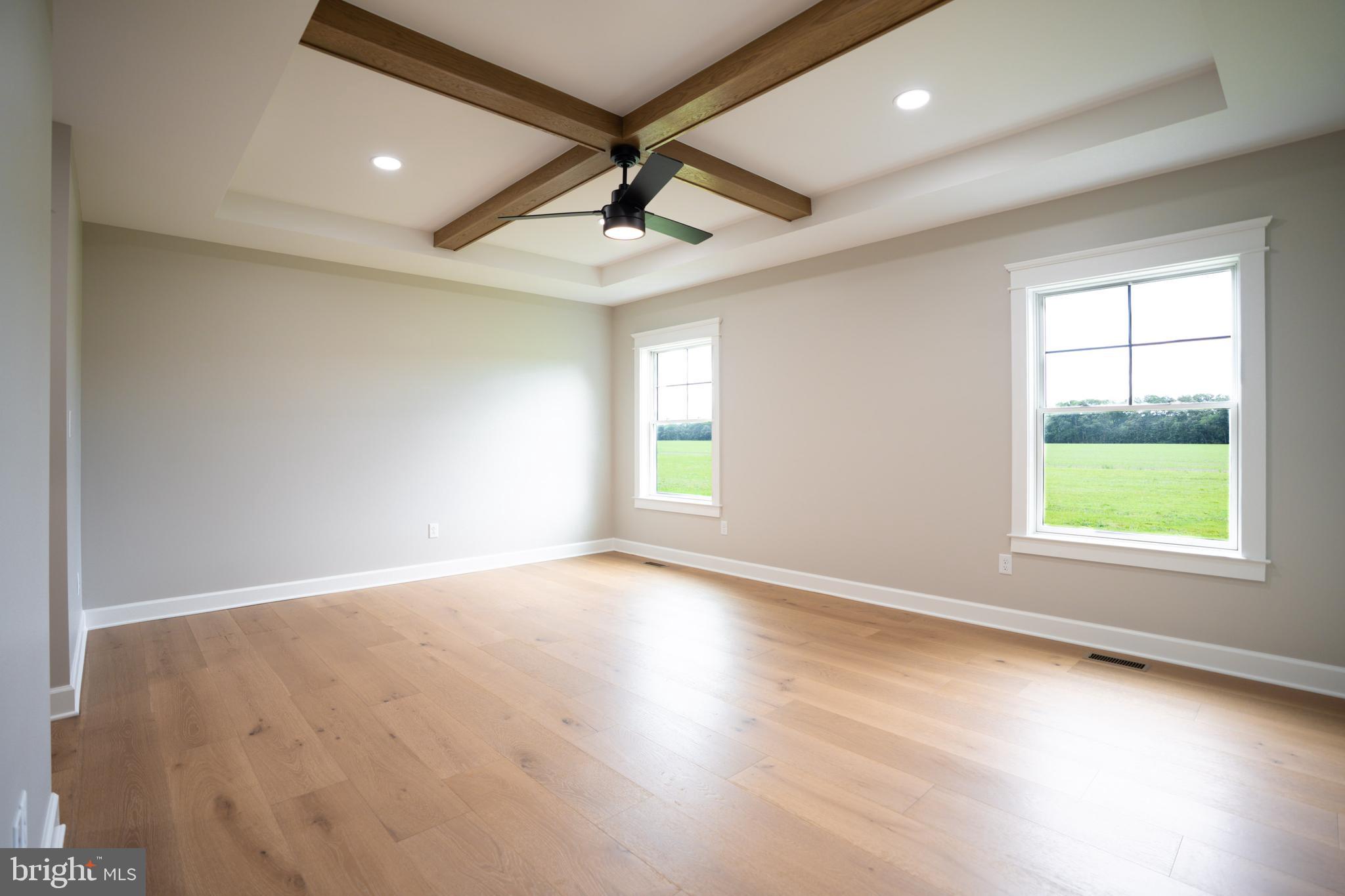 22430 Hummingbird Road Ellendale, DE 19941 - Photo 9 of 39 an empty room with wooden floor chandelier and windows