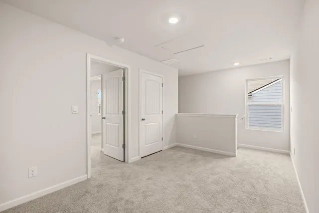 a view of hallway with closet and wooden floor