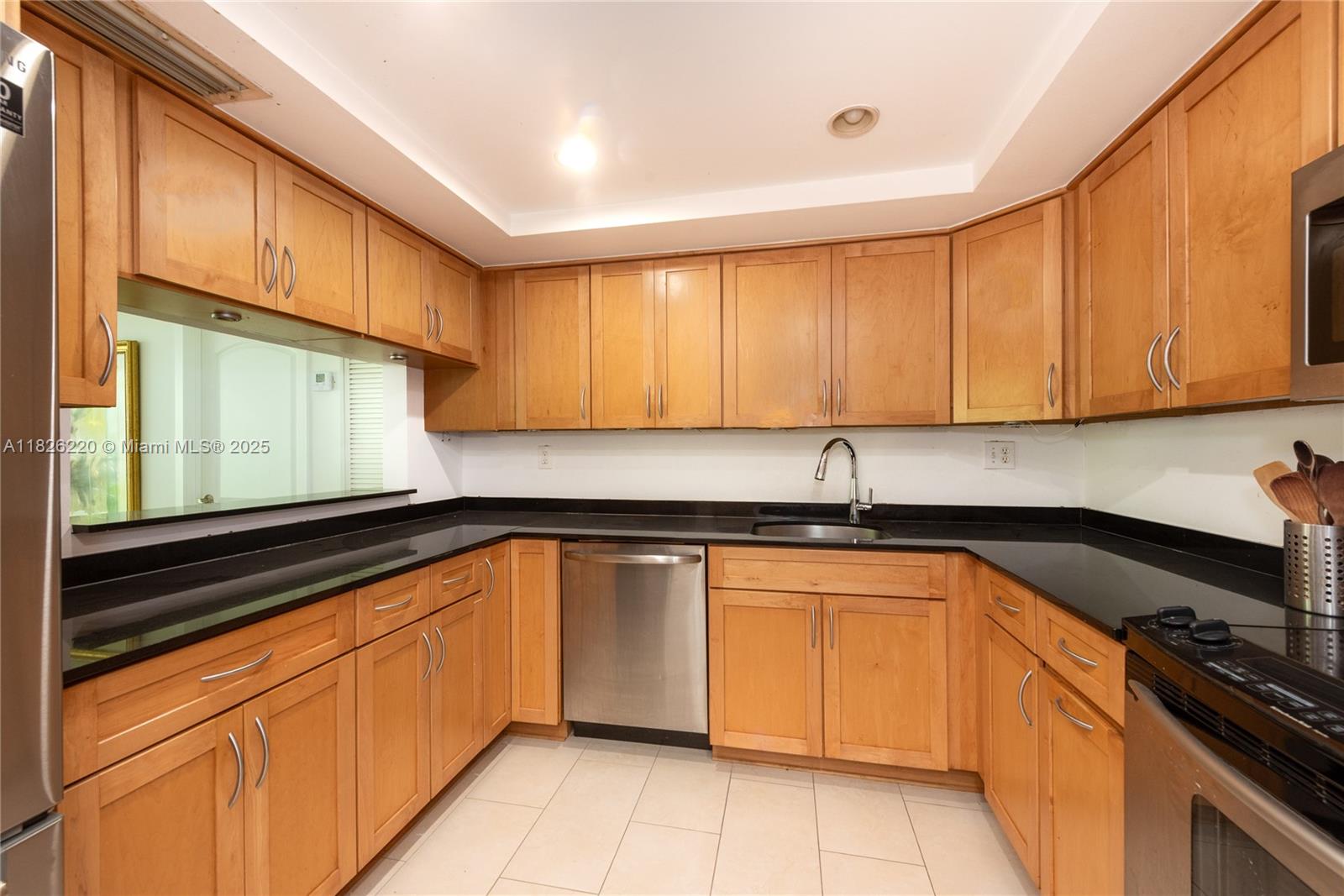 101 Ocean Ln Drive, Unit 2017 Key Biscayne, FL 33149 - Photo 24 of 25 a kitchen with granite countertop cabinets sink and white appliances