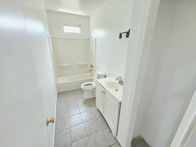 a bathroom with a granite countertop sink a toilet and shower