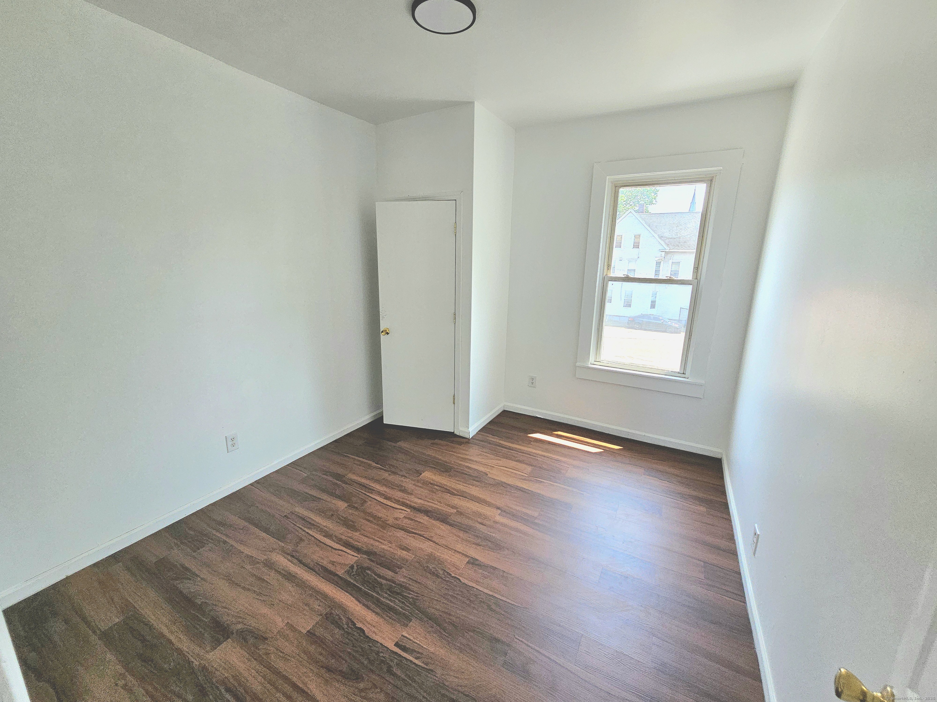 483 Ferry Street, Unit 2 New Haven, CT 06513 - Photo 9 of 11 an empty room with wooden floor and windows